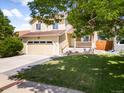 Charming two-story home with a well-kept lawn, a two-car garage, and a cozy front porch, ideal for a growing Gathering at 6318 Newton Ct, Arvada, CO 80003
