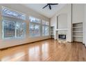 Spacious living room featuring hardwood floors, high ceilings, large windows, fireplace, and built-in shelving at 13322 Marion St, Thornton, CO 80241