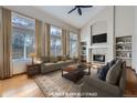 Bright, virtually staged living room featuring high ceilings, large windows, fireplace, and built-in shelving at 13322 Marion St, Thornton, CO 80241