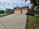 Spacious driveway leading to a two car garage, framed by blooming flower beds at 2239 S Truckee St, Aurora, CO 80013