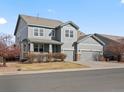 Charming two-story home featuring a covered porch, well-manicured lawn, and a three-car garage at 10730 Hillrose St, Parker, CO 80134