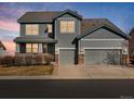 Two-story home showcasing a well-maintained lawn, three-car garage, and attractive landscaping at 10730 Hillrose St, Parker, CO 80134