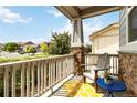 Inviting front porch featuring stone columns, a cozy chair, and a charming yellow and white patterned rug at 10730 Hillrose St, Parker, CO 80134