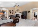 Cozy living room features neutral walls, vaulted ceiling, ceiling fan, fireplace, and plush seating at 6267 N Dunkirk Ct, Aurora, CO 80019