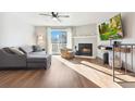 Bright living room with a fireplace, hardwood floors, a ceiling fan, and a sliding glass door to the outside at 9044 W 63Rd Ave, Arvada, CO 80004