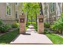 Inviting walkway with brick pillars leading to a serene path surrounded by mature trees at 335 Josephine St # D, Denver, CO 80206