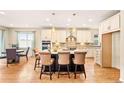 Open kitchen featuring an island with seating, pendant lighting, modern appliances, and a view to the dining area at 18175 W 94Th Ave, Arvada, CO 80007