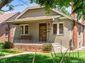 Inviting front exterior of a quaint home featuring a porch swing and landscaped garden at 4250 Wyandot St, Denver, CO 80211