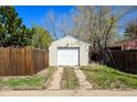 Single car garage with a white door, surrounded by a wooden fence and foliage at 3492 S Elm St, Denver, CO 80222