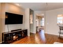 Living room featuring wood floors, a large TV, and a media console at 535 Lost Valley Pt, Castle Rock, CO 80108