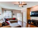 Comfortable living room features hardwood floors, a ceiling fan, and a large sectional couch at 535 Lost Valley Pt, Castle Rock, CO 80108