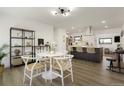 Bright dining area with a modern round table and open view to the stylish kitchen with a large island at 4895 E Arizona Ave, Denver, CO 80246