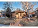Attractive single-story brick home showcasing a landscaped front yard with mature trees at 2434 S Ogden St # 2434-2436, Denver, CO 80210