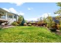 Spacious backyard featuring lush green grass, mature trees, and a privacy fence, perfect for outdoor activities at 6143 Eldora St, Golden, CO 80403