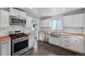 Bright kitchen featuring white cabinets, stainless steel appliances, and butcher block countertops at 1801 S Eudora St, Denver, CO 80222