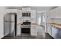 Well-lit kitchen boasts stainless steel appliances, wooden countertops, and ample cabinet space at 1801 S Eudora St, Denver, CO 80222
