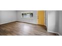 Spacious living room with hardwood floors and plenty of natural light, featuring a bright yellow front door at 1801 S Eudora St, Denver, CO 80222
