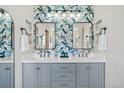 Stylish bathroom with double vanity, quartz countertops, and designer wallpaper at 10570 Humboldt Peak Way, Parker, CO 80138