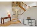 Inviting foyer with a wooden staircase, console table, and decorative accents, creating a warm entrance at 10570 Humboldt Peak Way, Parker, CO 80138