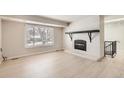 Spacious living room with fireplace, large window, and tile floors at 2221 S Arbutus Ct, Lakewood, CO 80228