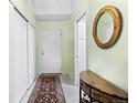 Entry hall featuring a decorative mirror, coat closet, storage console, and a vibrant Persian rug at 7877 E Mississippi Ave # 607, Denver, CO 80247