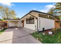 Beautiful home featuring a unique roofline, white siding, and well-manicured landscaping at 1392 S Edison Way, Denver, CO 80222
