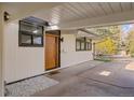Welcoming front entry featuring a modern wood door and stone landscaping at 1392 S Edison Way, Denver, CO 80222