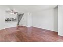 Spacious living room with hardwood floors, ceiling fan and easy access to the staircase at 14465 E Hawaii Cir # A, Aurora, CO 80012