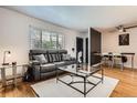 Inviting living room with hardwood floors, a leather sofa, and a stylish glass coffee table, perfect for relaxation at 5184 E Asbury Ave, Denver, CO 80222