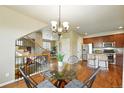 Open dining room features a modern chandelier, hardwood floors, and staircase access at 1100 Rockhurst Dr # A, Highlands Ranch, CO 80129