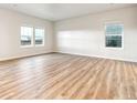Spacious living room with beautiful wood floors, and bright sunny windows at 19058 E 94Th Pl, Commerce City, CO 80022