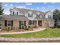 Charming two-story home featuring a brick and gray facade, complemented by mature landscaping and a welcoming walkway at 20363 E Top T Ranch Pl, Parker, CO 80134