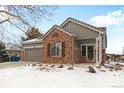 Brick ranch home with attached garage and snowy front yard at 11931 Fairplay St, Commerce City, CO 80603