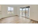 Bright living space featuring wood flooring, a large window, and sliding glass doors to the outside deck at 661 Sunrise St, Erie, CO 80516