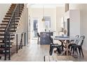 Bright living room with modern floating stairs, open concept to kitchen, and dining area, boasting light hardwood floors at 5125 W 29Th Ave # 5, Denver, CO 80212