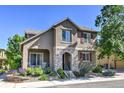 Charming two-story home featuring a stone-accented entrance and covered patio, surrounded by lush landscaping at 10550 Ashfield St, Highlands Ranch, CO 80126