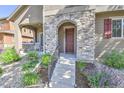 Inviting front porch with stone archway, manicured landscaping, and cozy seating at 10550 Ashfield St, Highlands Ranch, CO 80126