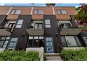 Modern townhome featuring a mix of wood and black metal siding, private balconies, and bright blue doors at 1534 Irving St, Denver, CO 80204