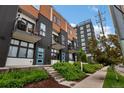 Modern townhome with balconies, contrasting wood and dark siding and landscaped entrances at 1534 Irving St, Denver, CO 80204