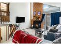 Cozy living room featuring a fireplace with a wood panel accent wall, a TV, and comfortable seating at 3852 S Genoa Ct # B, Aurora, CO 80013