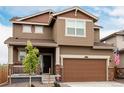 Home exterior featuring a brown siding, covered porch, and an attached two-car garage at 870 Mosquito Ct, Elizabeth, CO 80107