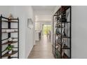 Bright hallway with wood floors and decor shelves leading to open kitchen and dining area at 870 Mosquito Ct, Elizabeth, CO 80107