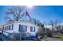 Charming home exterior with an American flag, a small yard, and surrounded by bare winter trees at 815 Plum Ave, Lochbuie, CO 80603