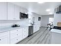 Renovated kitchen features stainless steel appliances, white cabinets, and light wood flooring at 815 Plum Ave, Lochbuie, CO 80603