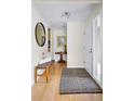 Inviting entryway featuring a wood bench, decorative rug, and a striking round mirror to add to the decor at 6843 Fairview Dr, Boulder, CO 80303
