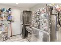 The kitchen features a washer/dryer in addition to a stainless steel fridge and stocked shelving at 3081 W 18Th Ave, Denver, CO 80204