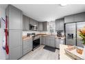 Bright kitchen featuring gray cabinets and stainless steel appliances at 1502 Carmelita Ct, Platteville, CO 80651