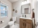 Well-lit powder room with a modern vanity, decorative wall hangings, and a neutral color palette at 2418 Coach House Loop, Castle Rock, CO 80109