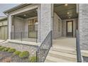 Covered front porch with gray brick exterior and black railing at 1853 Hickory Ave, Erie, CO 80516