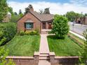 Charming brick home with a well-manicured lawn and a stone walkway leading to the entrance at 2300 Jasmine St, Denver, CO 80207